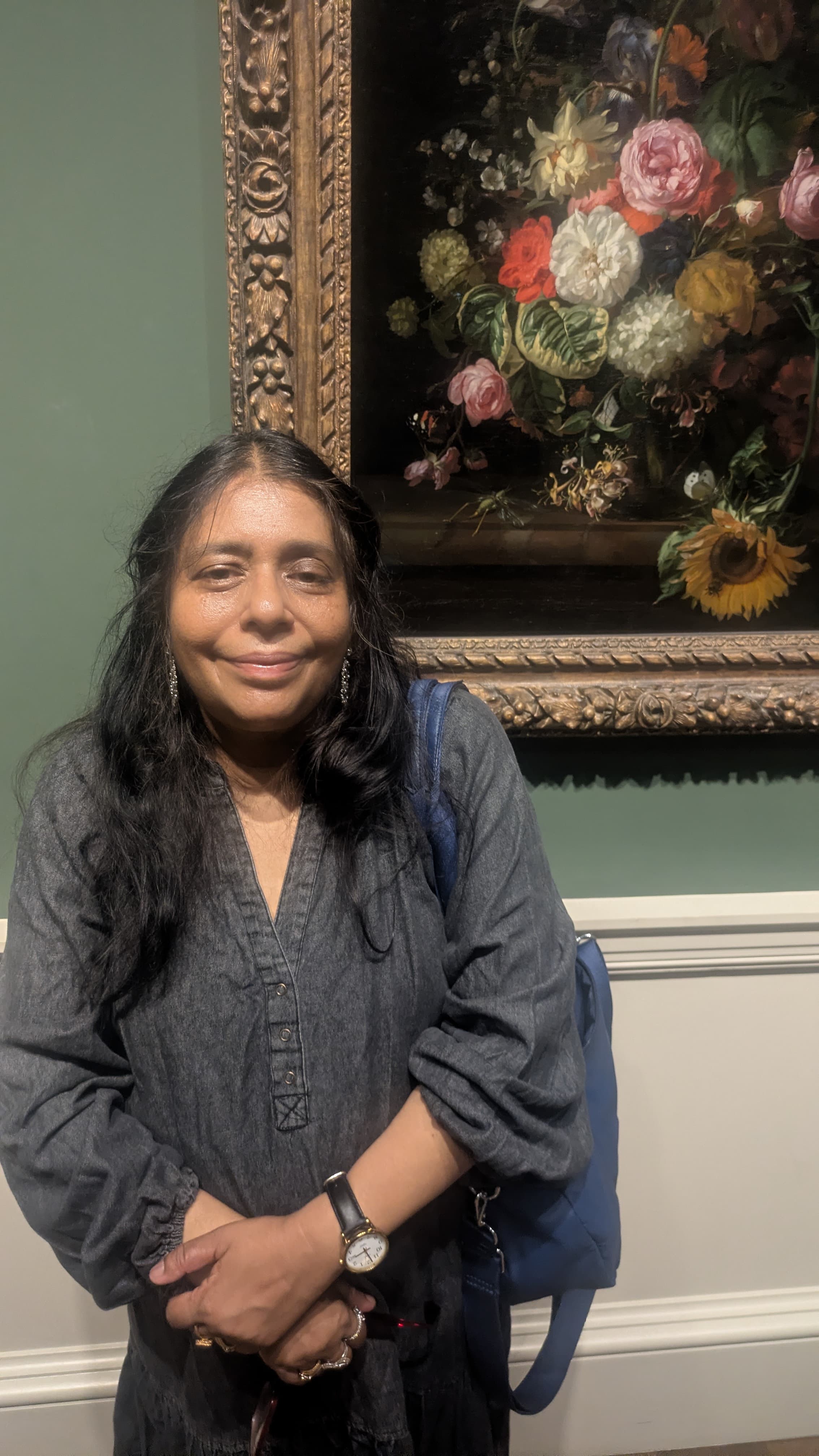 Hushpetal founder standing beside a framed floral painting
